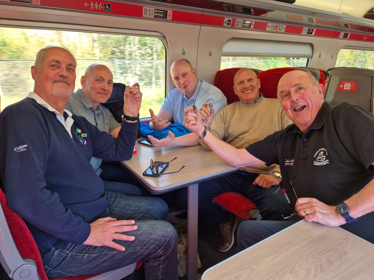 Five members in good spirits around a table on the train